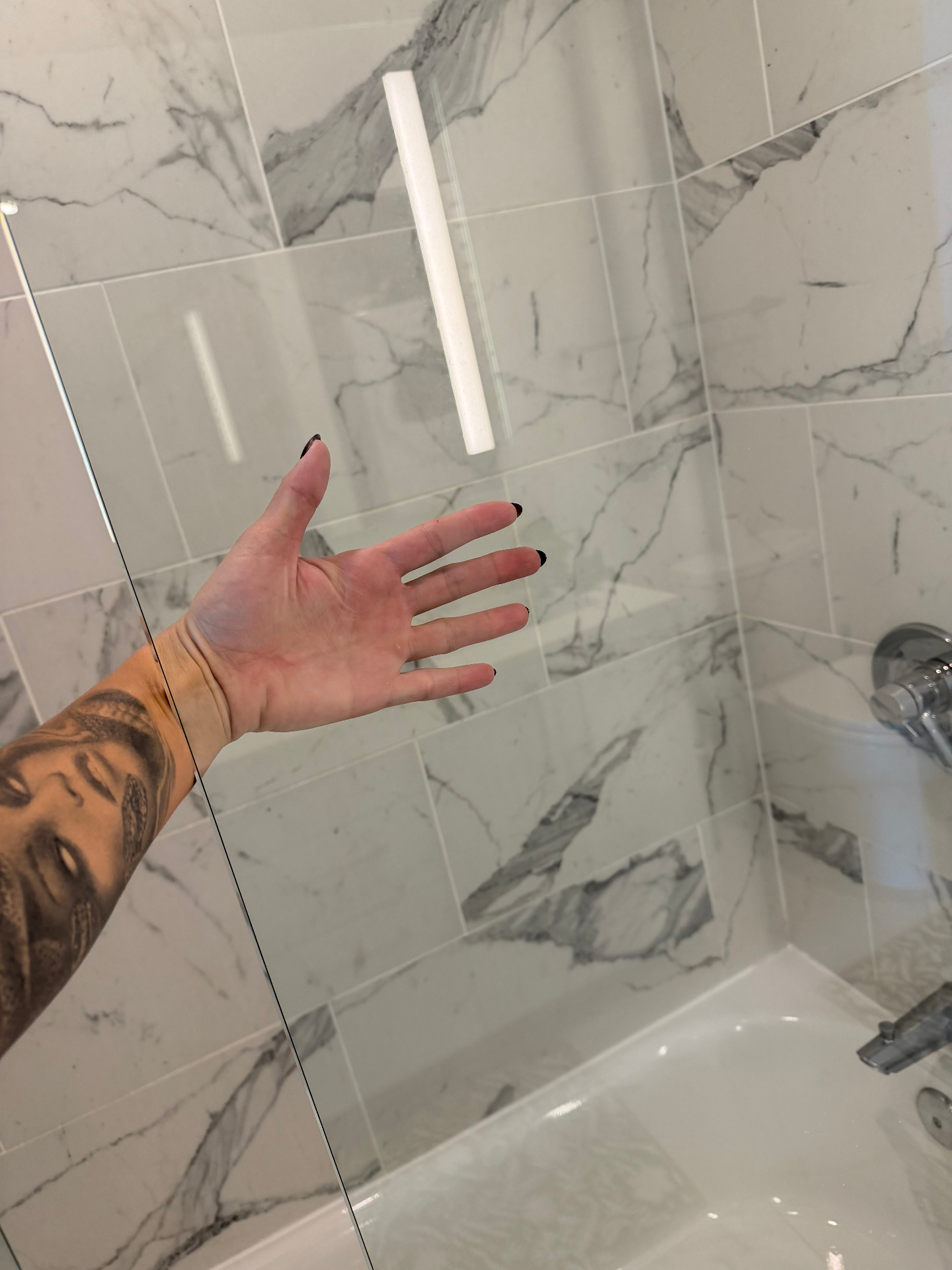 Perfectly clear shower glass and marble tile after cleaning